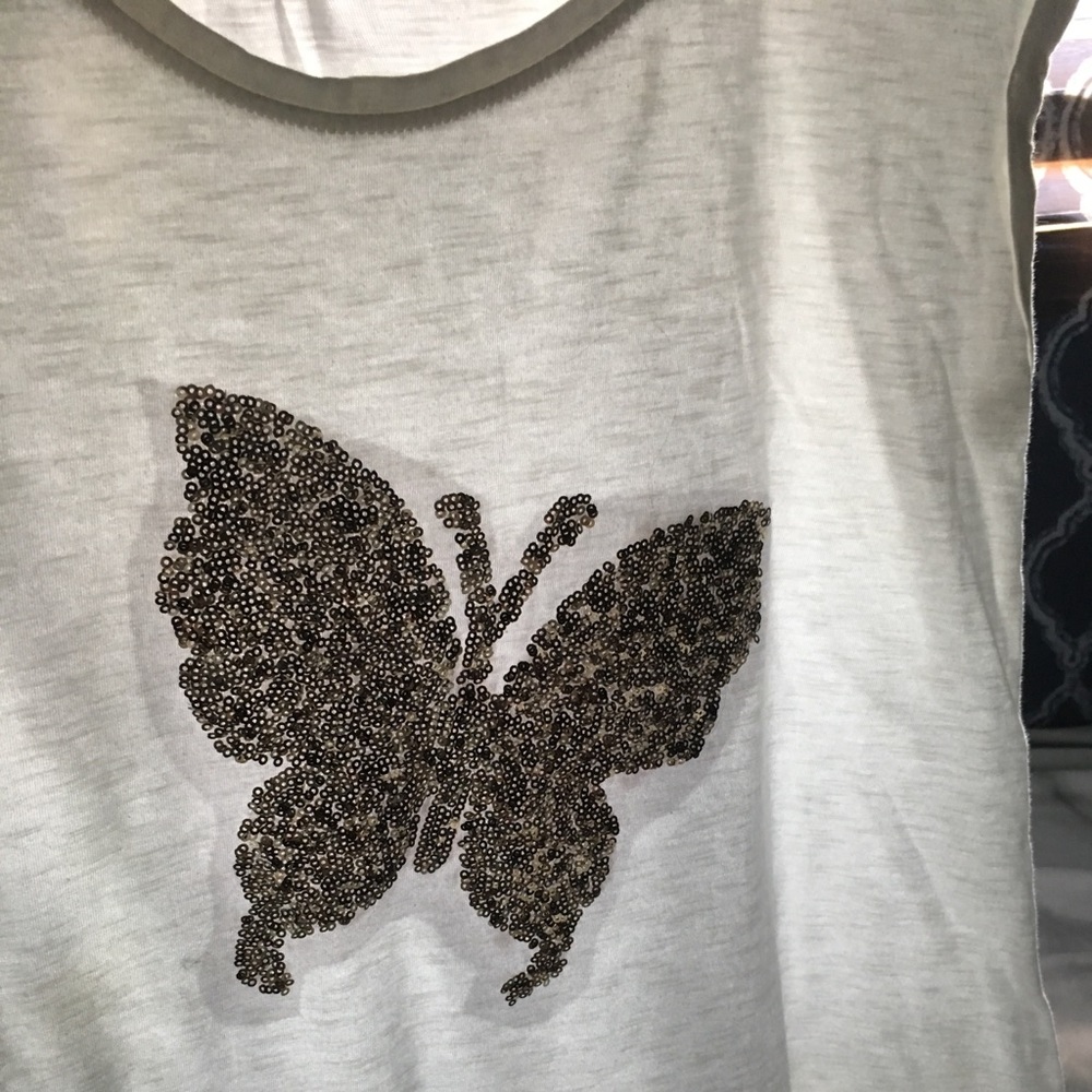 A long white tee type dress with gold butterfly